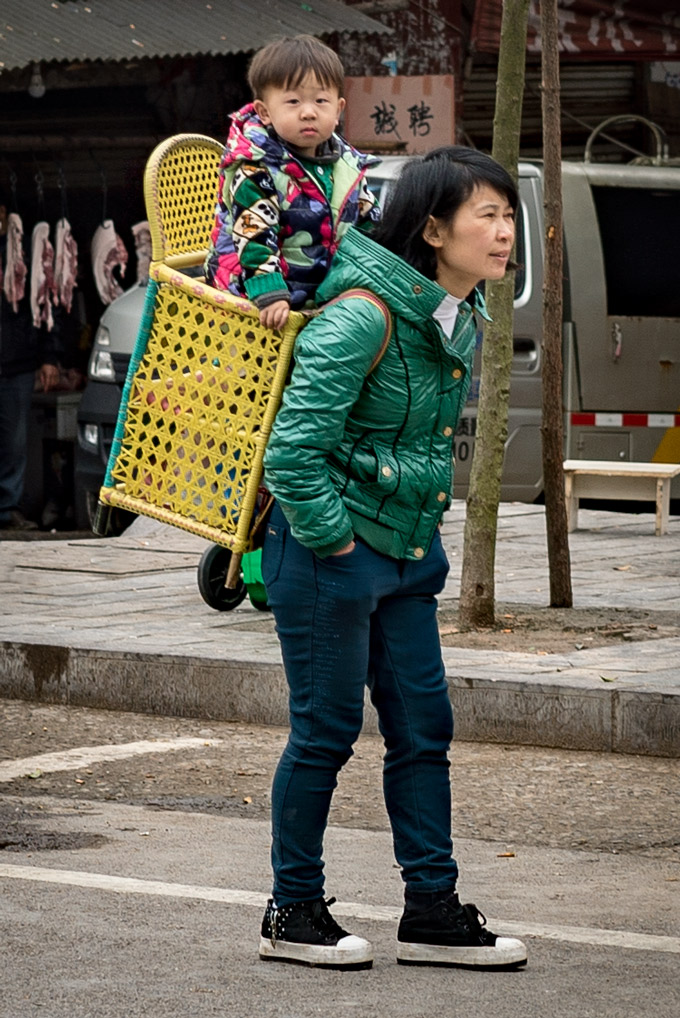 Mother carrying child on back in Zhangjiajie, China