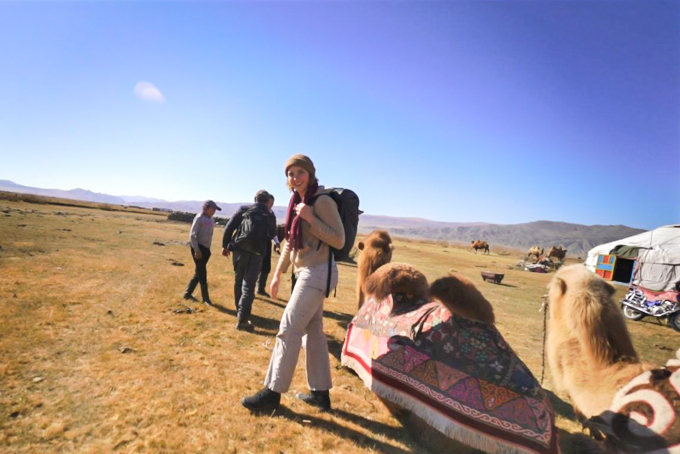 Ansley Sawyer walking in Mongolia with a camel at her side