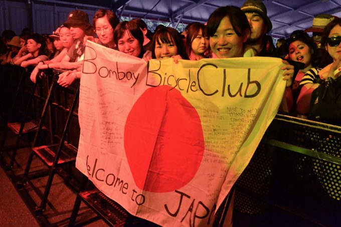 fuji rock festival concertgoers holding bombay bicycle banner