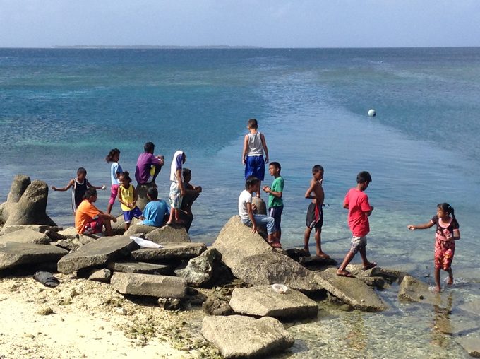 kids on rock at ocean, Ebeye, Marshall Islands