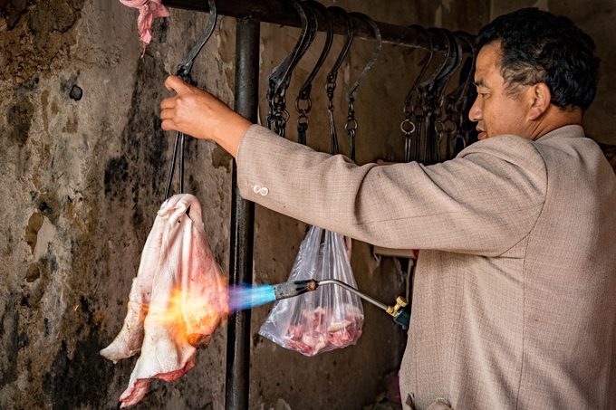 Butcher torching meat in Zhangjiajie, China