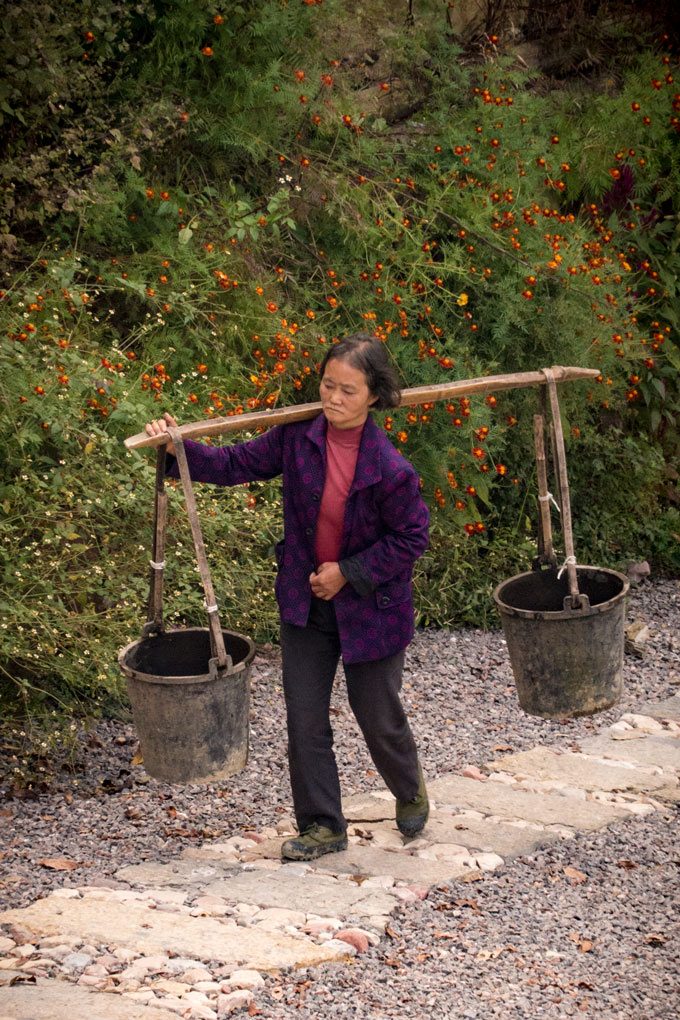 Woman carrying water buckets in Yangjiajie, China