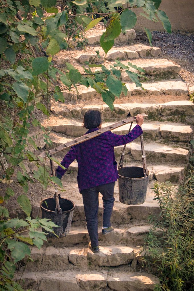 Woman carrying water in Yangjiajie, China