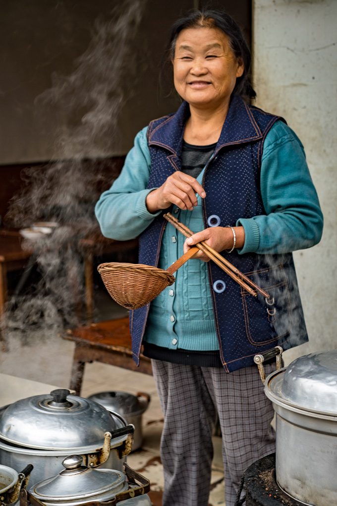 Woman cooking street food in Zhangjiajie, China
