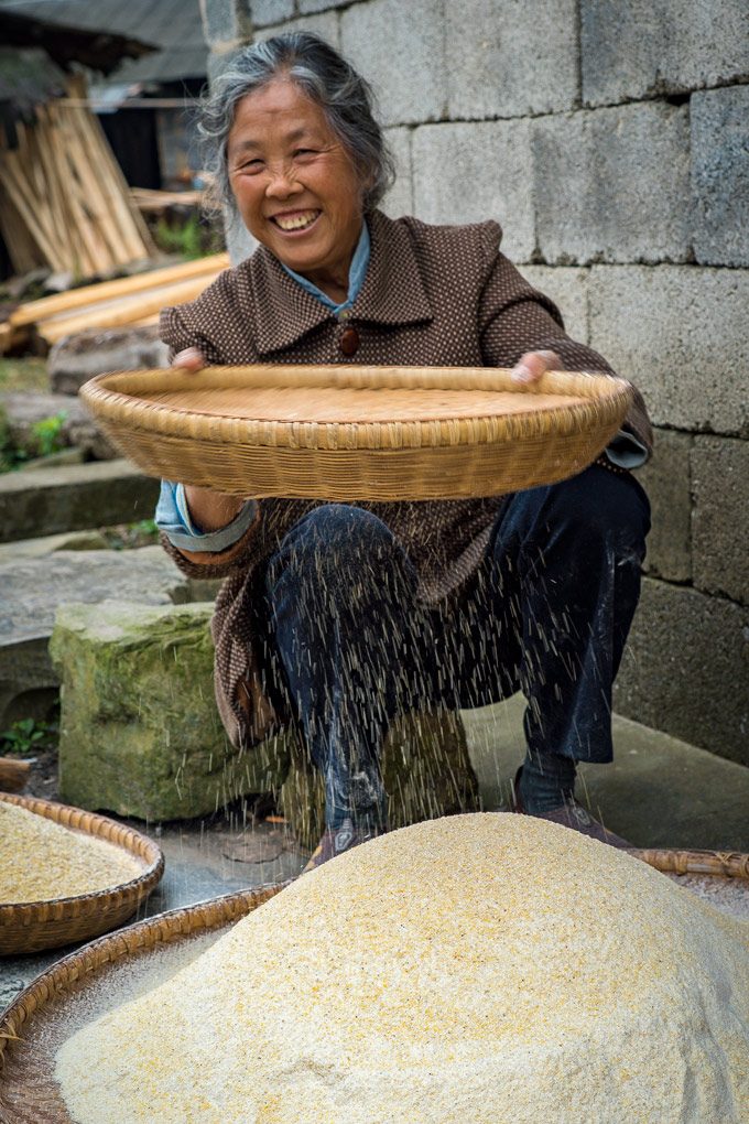 Woman sifting flour in Zhangjiajie, China