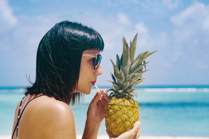 Jessica Peterson of Global Girl Travels sipping a pineapple on Saona Island, Dominican Republic for Barcelo Hotels, barcelostories.com